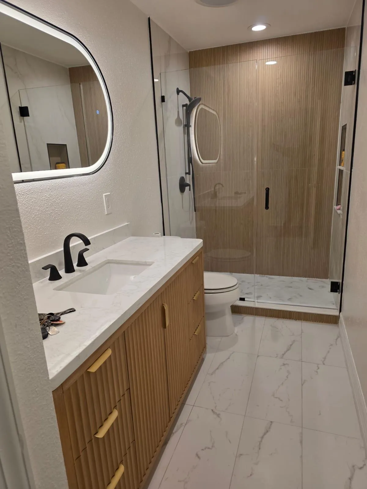 Bathroom with fluted oak vanity, quartz top and glass shower